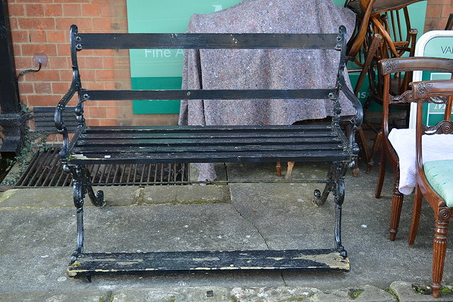 A Victorian black painted cast iron garden bench