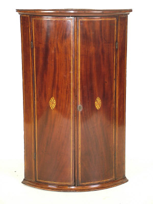 A George III bowfront mahogany corner cabinet circa 1800 the