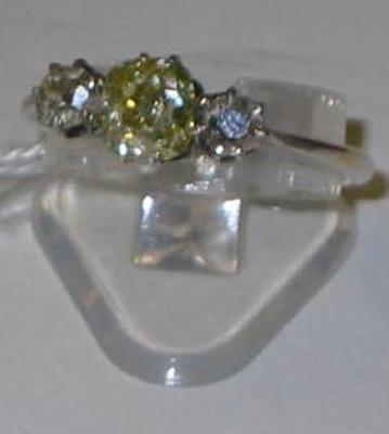 A THREE STONE DIAMOND RING comprising central champagne stone flanked