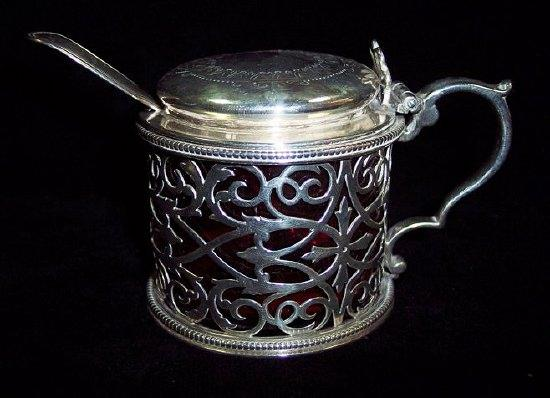 A circular mustard pot and cover with engraved lid trellis
