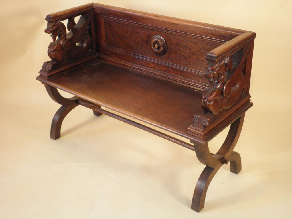 A Continental oak bench the raised back and sides with
