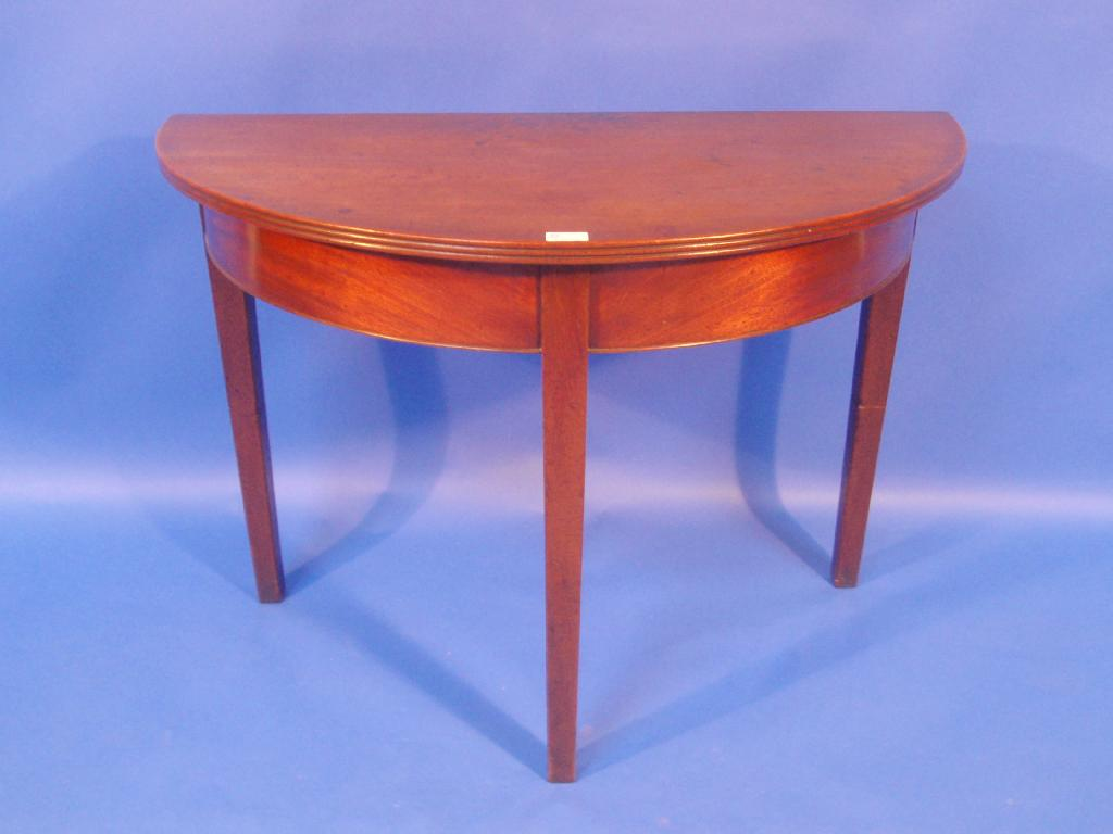 A 19thC mahogany demi lune table with reeded top and