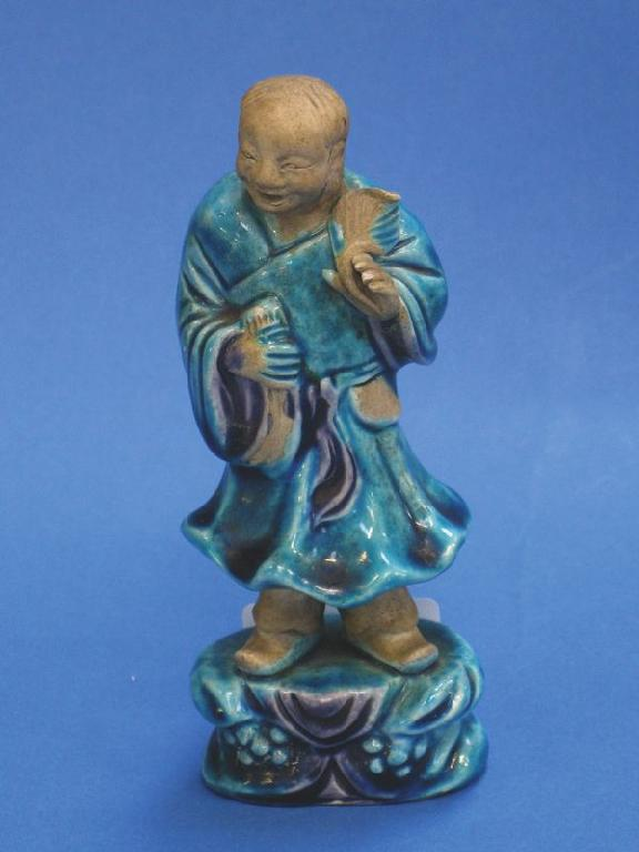 A CHINESE BISCUIT FIGURE of a man partially covered in