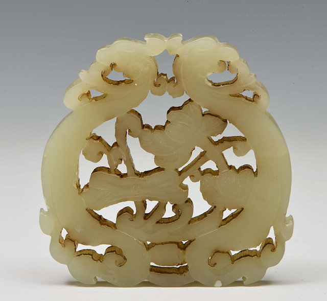 A CHINESE MUTTON FAT JADE PENDANT carved and pierced as