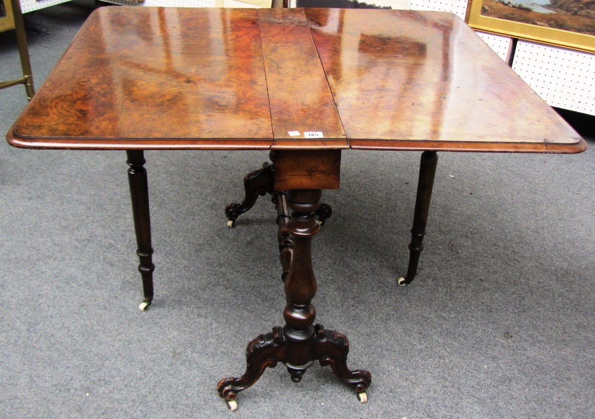 A Victorian figured walnut Sutherland table on baluster turned supports