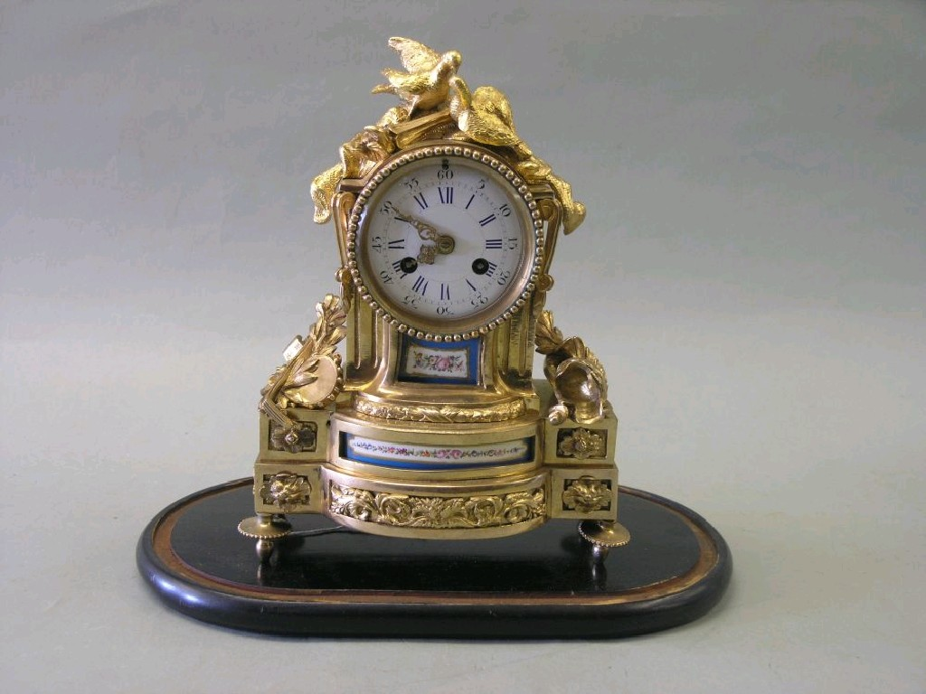 A 19th century French ormolu mantel clock featuring convex enamel