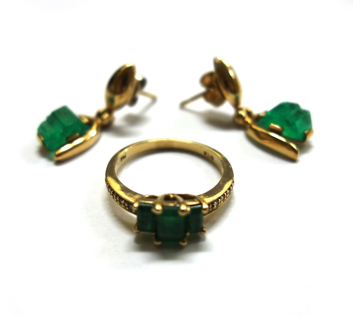 A gold emerald and diamond ring centred by three step