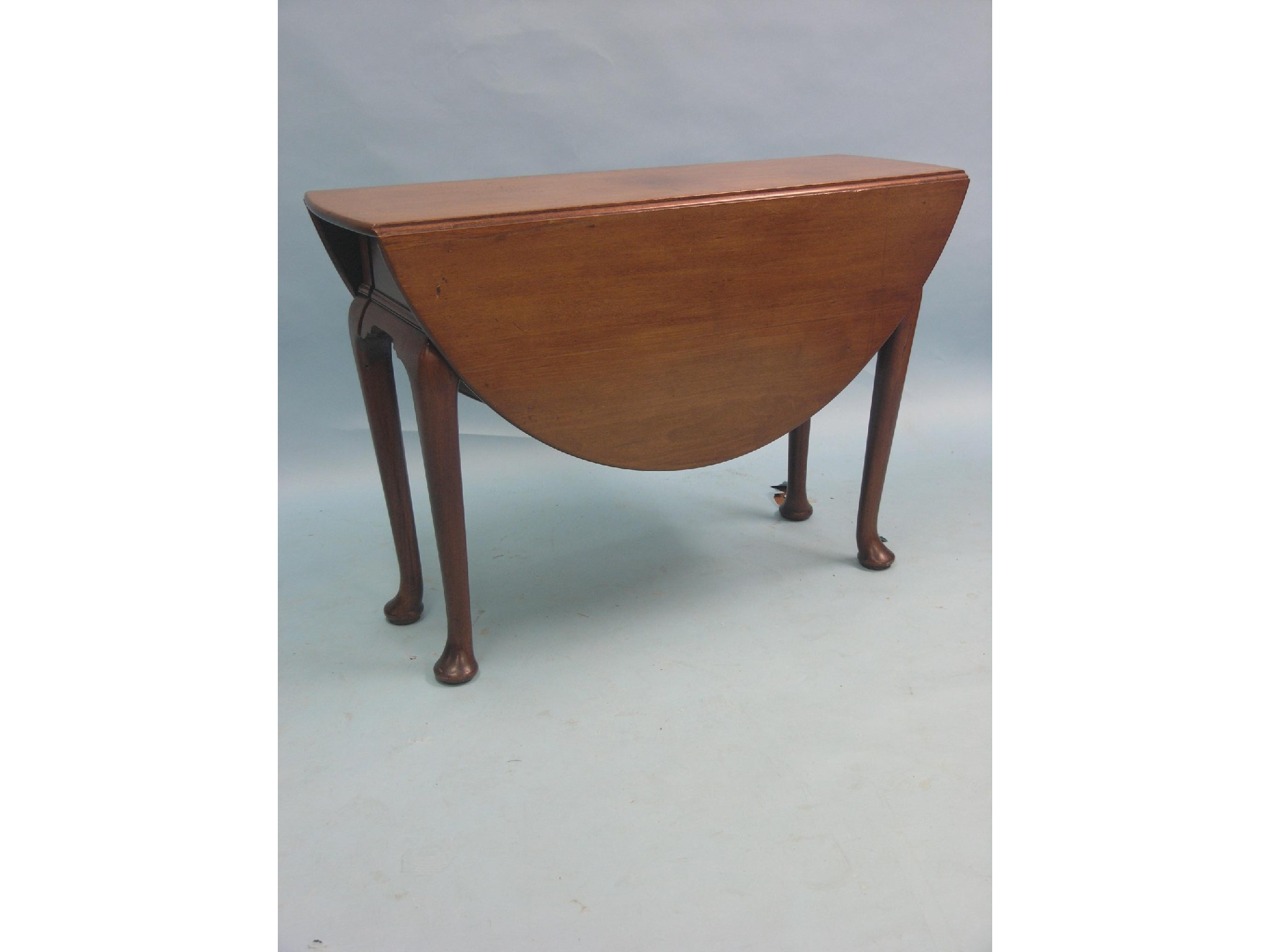A Georgian walnut drop leaf dining table on cabriole legs