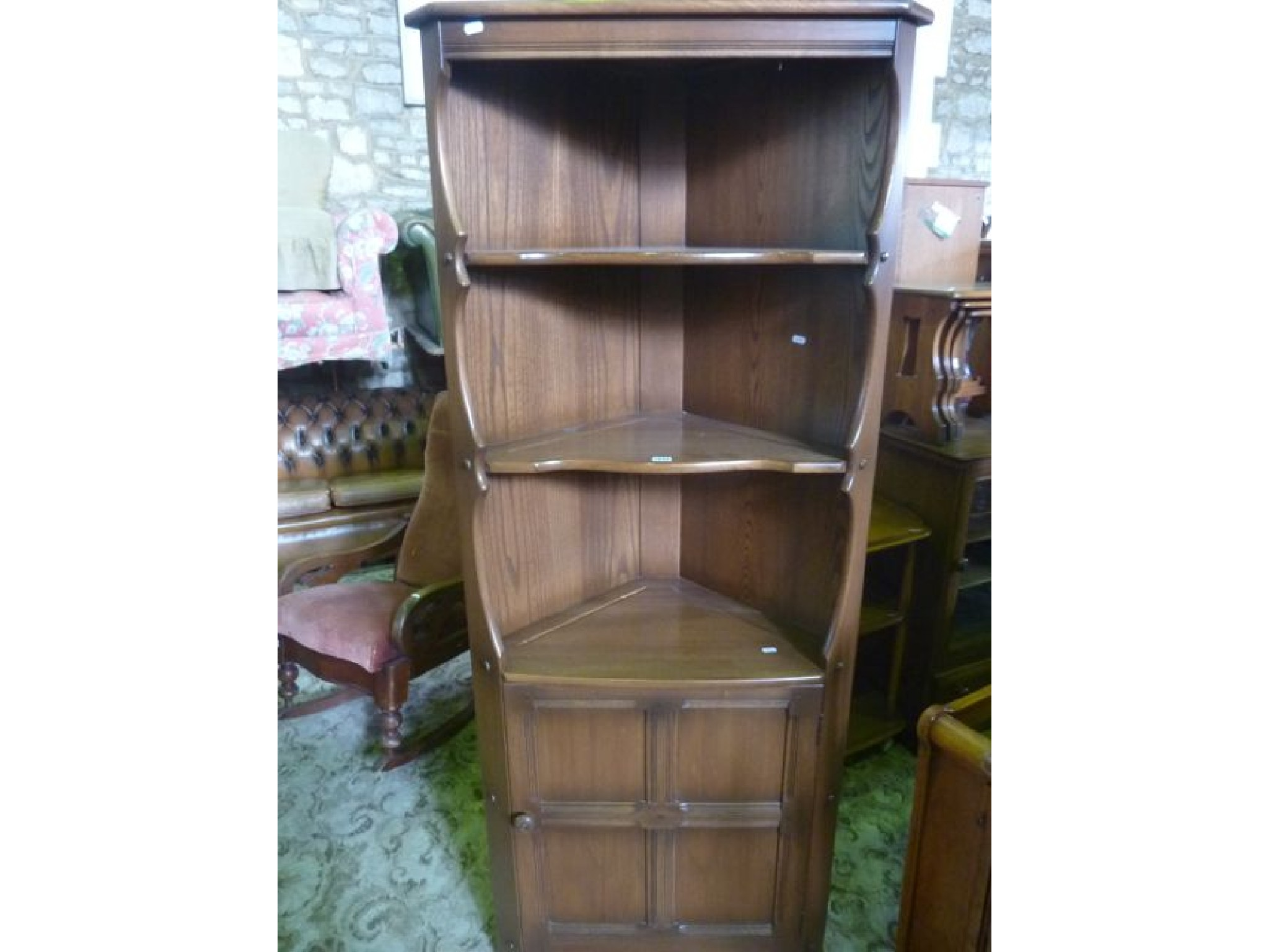 A contemporary Ercol medium elm Golden Dawn freestanding corner cupboard