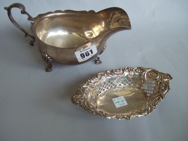 A silver sauce boat with a wavy rim with a