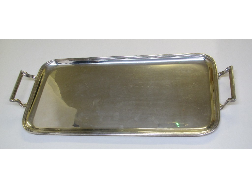 A silver two handled rectangular tea tray with reeded border