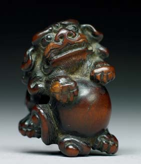CARVED EBONY NETSUKE Carved ebony netsuke of a shi shi