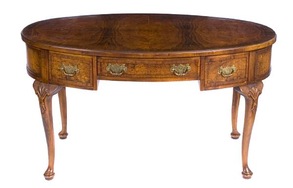 A George II style walnut writing desk of oval outline