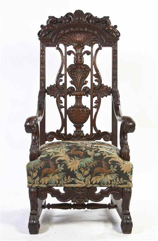 A Continental Carved Armchair having a scrollwork carved crest flanked