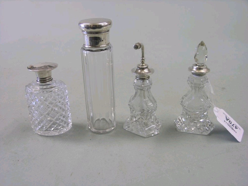 A silver mounted glass atomiser and three silver mounted scent