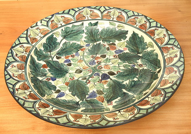 A LARGE WEDGWOOD TIN GLAZED CHARGER decorated with flowering foliage