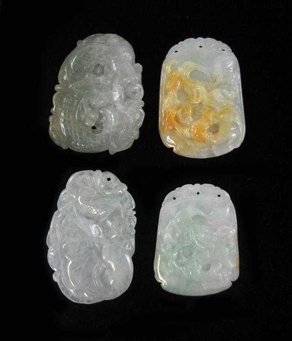 FOUR CHINESE CARVED JADE PENDANTS All four transparent light green