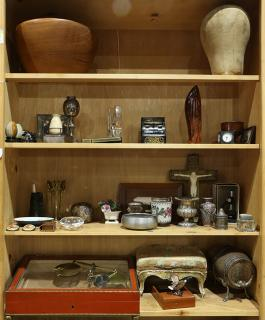 Six shelves of decorative art including a manekin head a