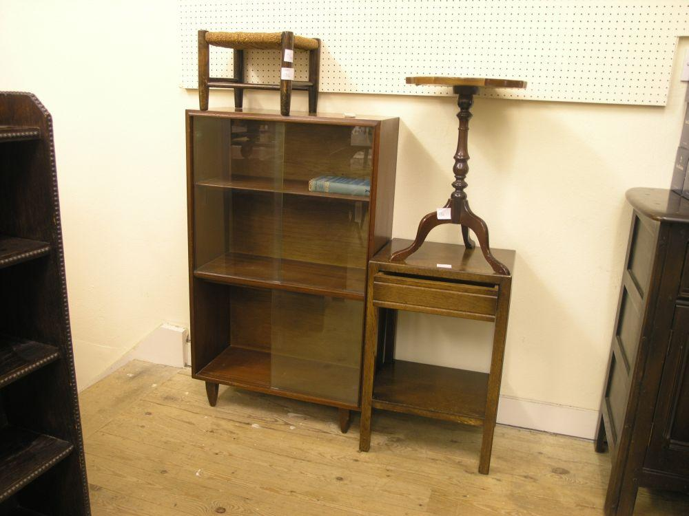 A mahogany bookcase enclosed by two pairs of sliding glass