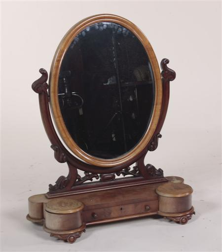 A Victorian mahogany oval dressing mirror the moulded frame raised
