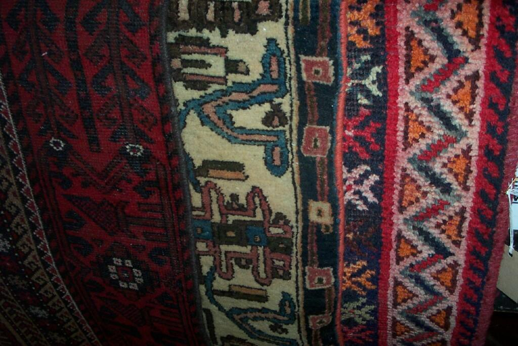 An eastern red ground wool rug with repeating hooked and