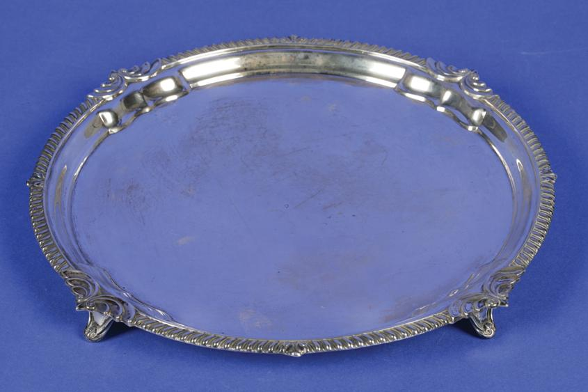 A GEORGE V SALVER of circular form with a raised