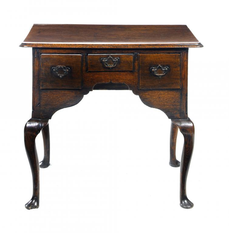 A GEORGE III OAK LOWBOY with three moulded drawers to
