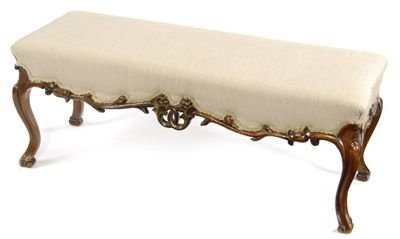 A Victorian carved walnut long stool the upholstered seat above