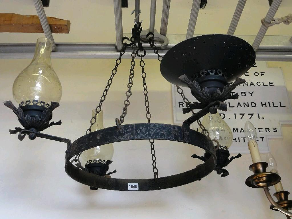 An iron framed hanging ceiling light of hooped form adorning