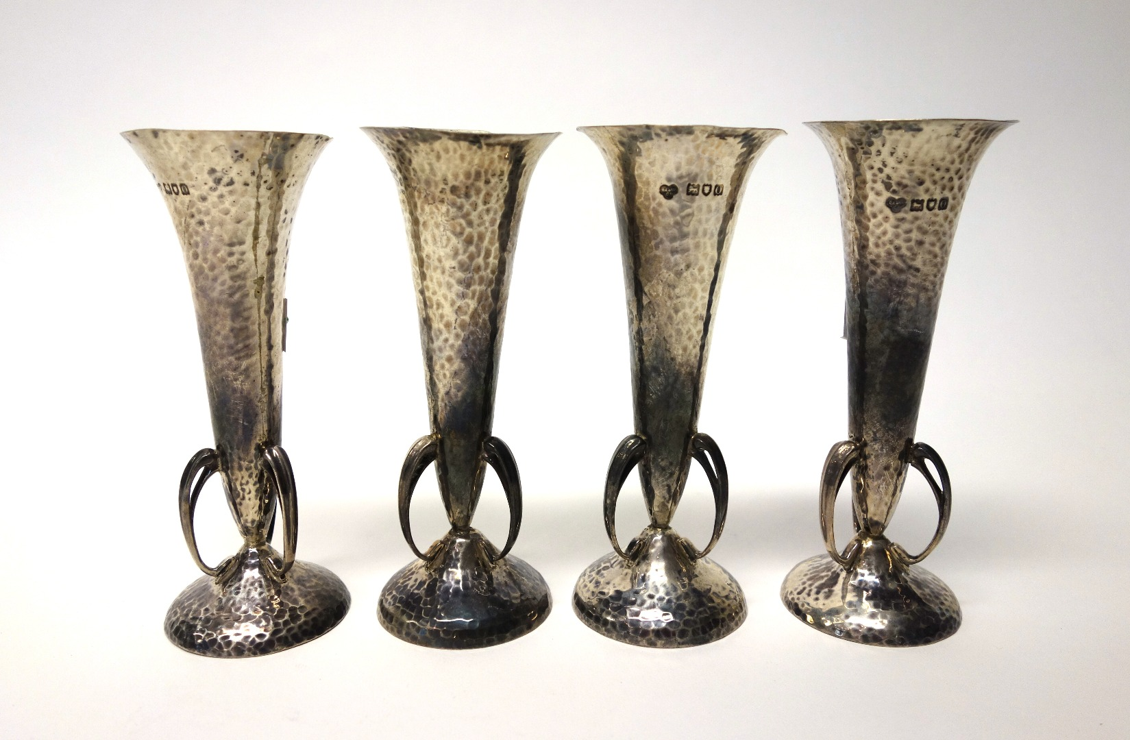 A set of four silver trumpet shaped vases having a