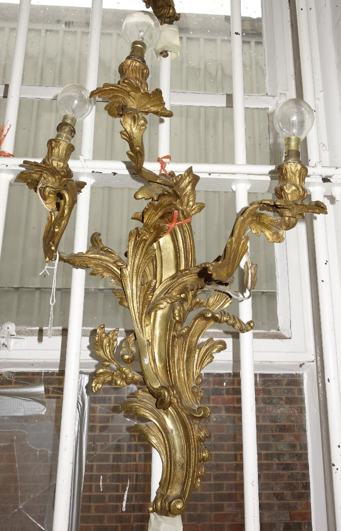 A pair of gilt metal rococo style three branch wall