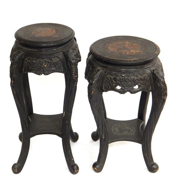 Pair of ebonized Chinese stands round tops with carved geometrically
