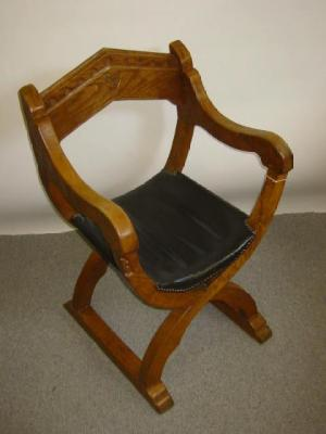 A THOMAS GNOMEMAN WHITAKER ARM CHAIR of X frame form