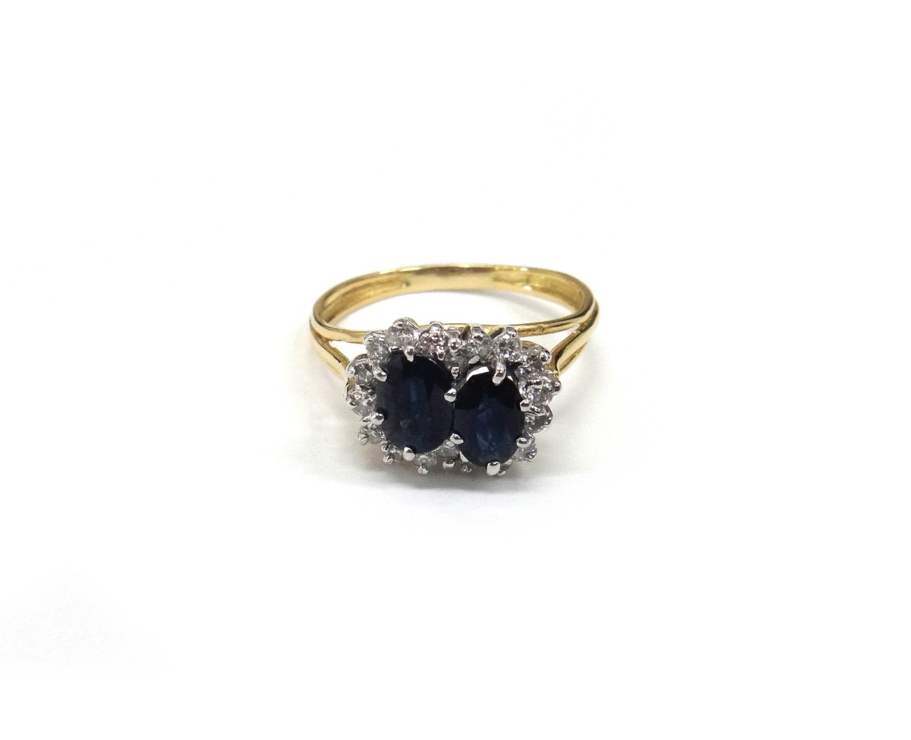A sapphire and diamond double cluster ring on a three