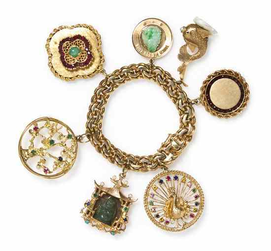 A 14 Karat Yellow Gold Charm Bracelet with Seven Attached