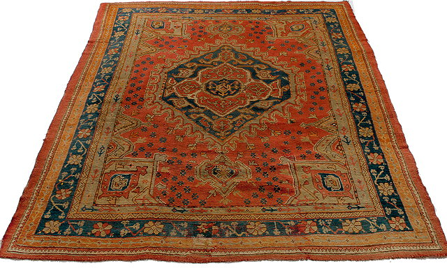 AN ANTIQUE TURKISH POLYCHROME SMALL CARPET with a central medallion