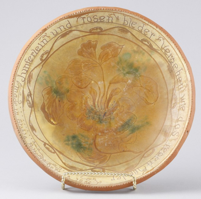 Redware plate features floral motif at center with verse in