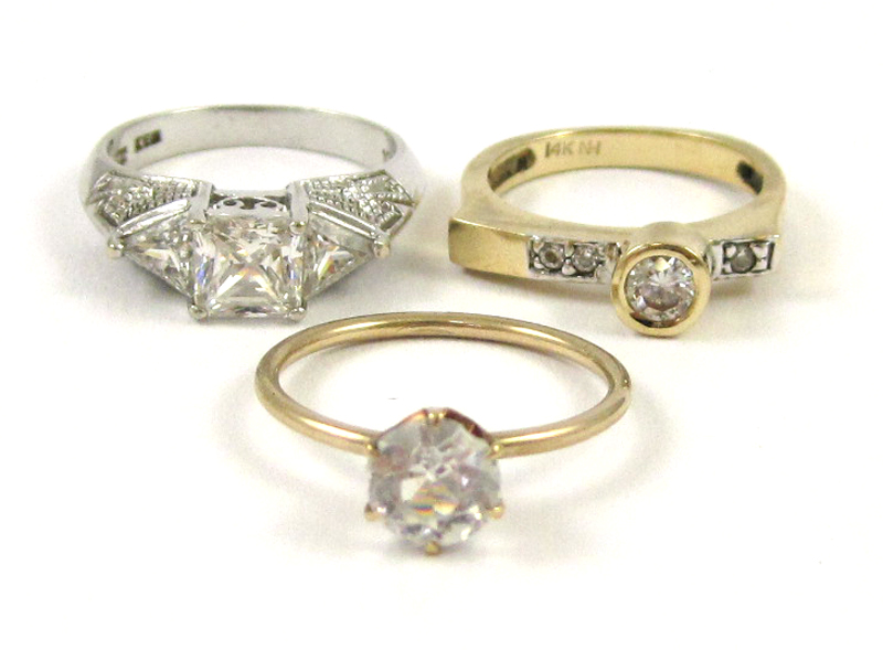 THREE FAUX DIAMOND AND GOLD RINGS including a size 7