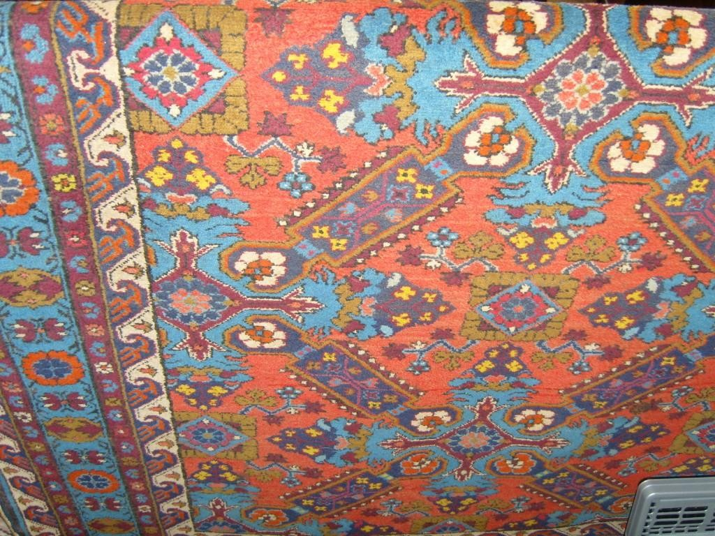 A red ground eastern wool rug with stylised floral decoration