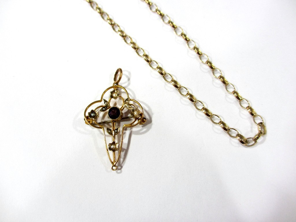An Edwardian 9ct gold open scroll pendant set with an