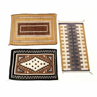 Three Navajo Area Rugs the first centered with an ivory