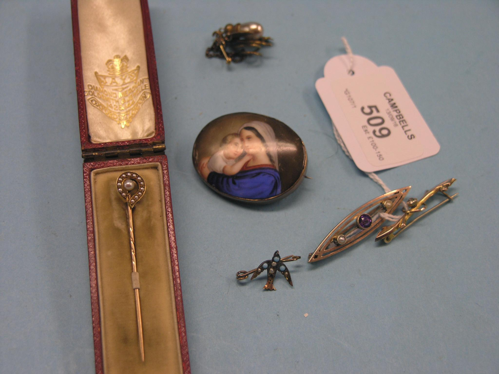 An Edwardian yellow metal stick pin set seed pearls in