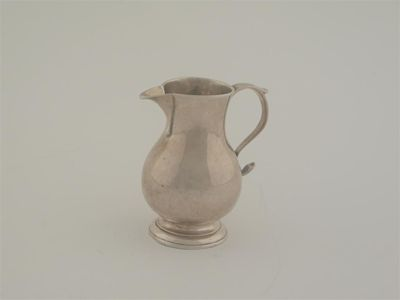 An early George II sparrow beak cream jug of baluster