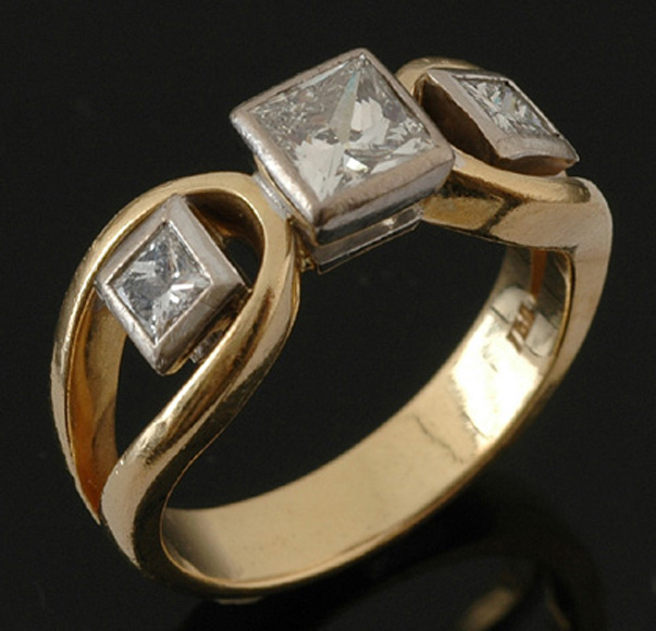 A three stone diamond ring Centrally set with a princess