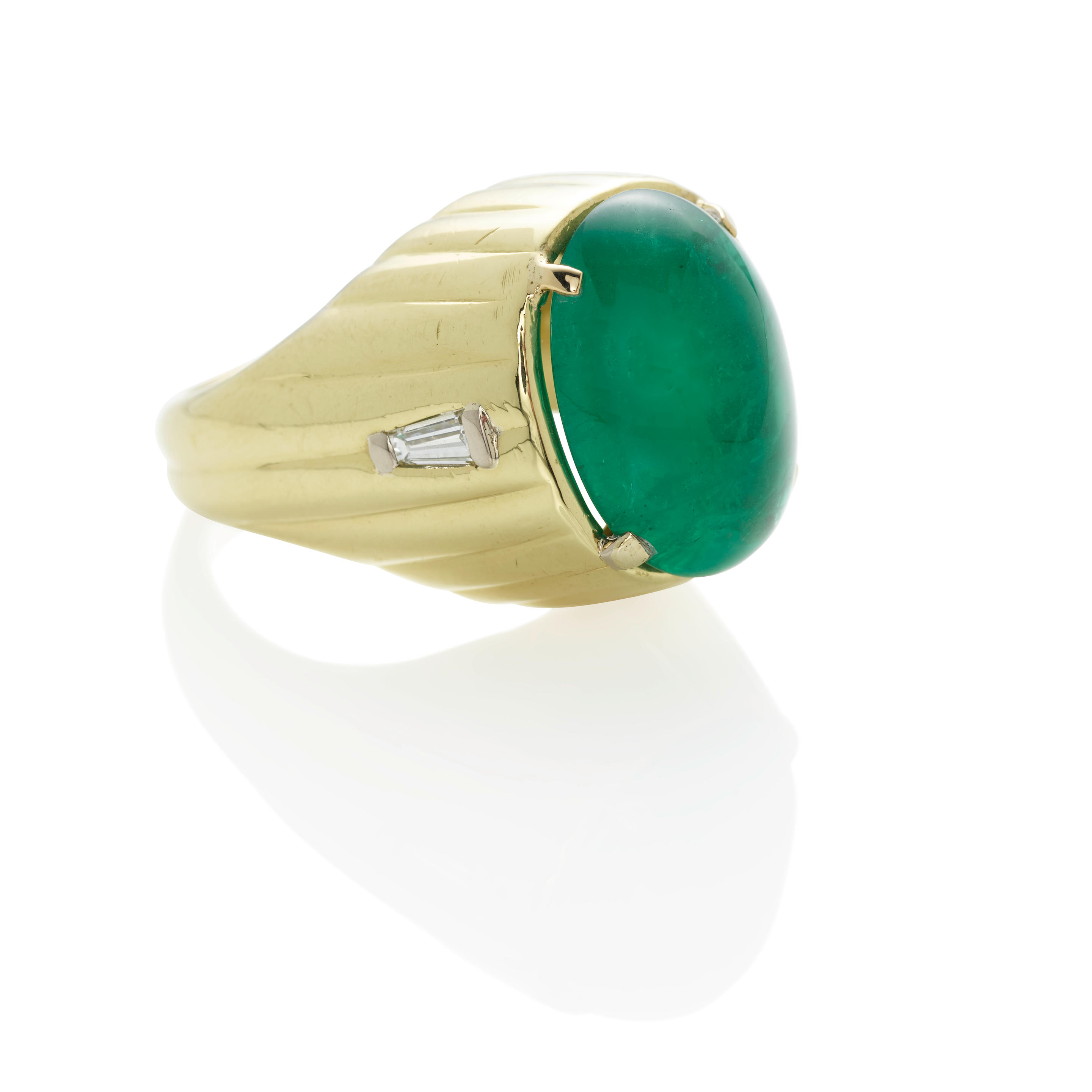 AN 18K GOLD EMERALD AND DIAMOND RING Centering an oval