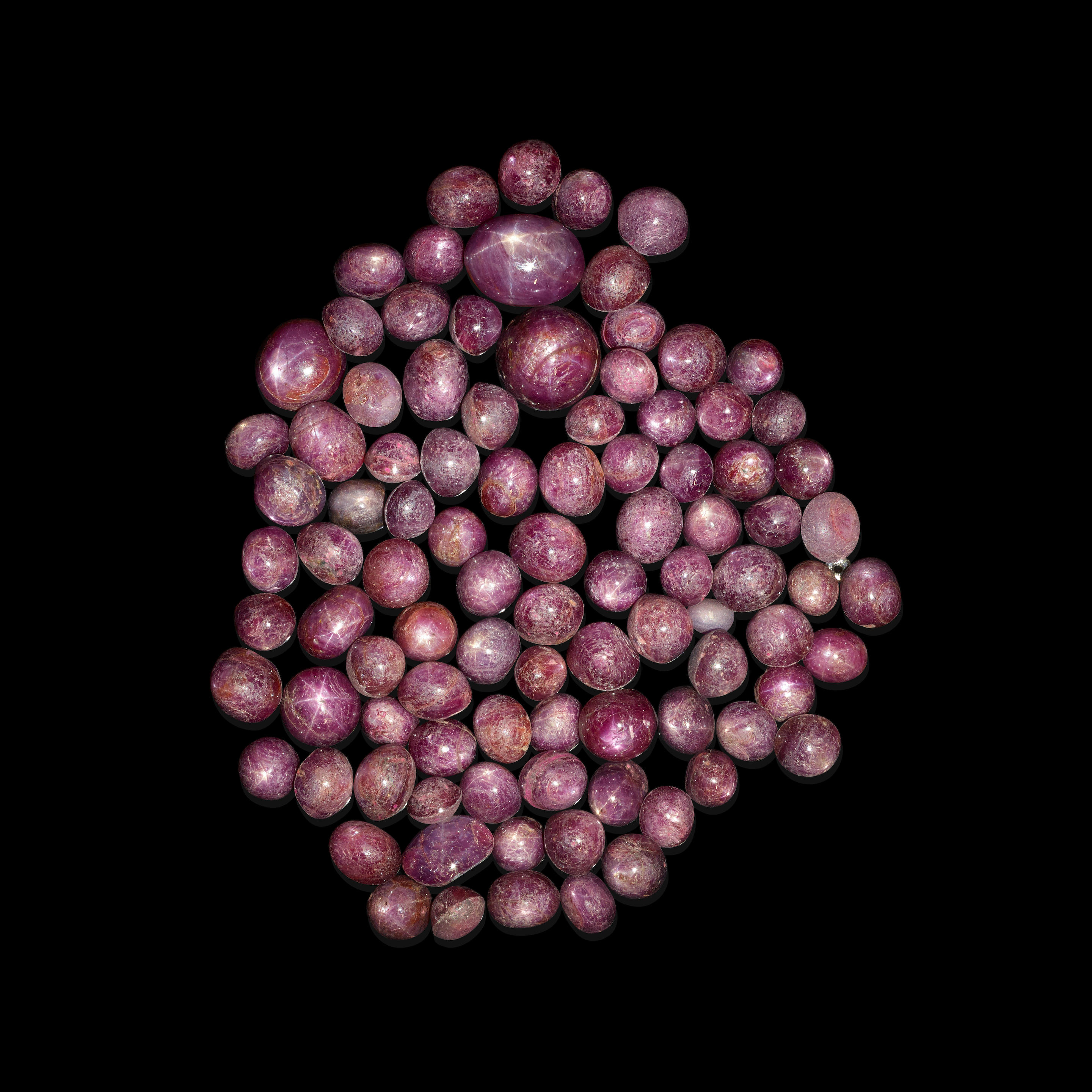 STAR RUBY CABOCHONS A group of circular and oval ruby