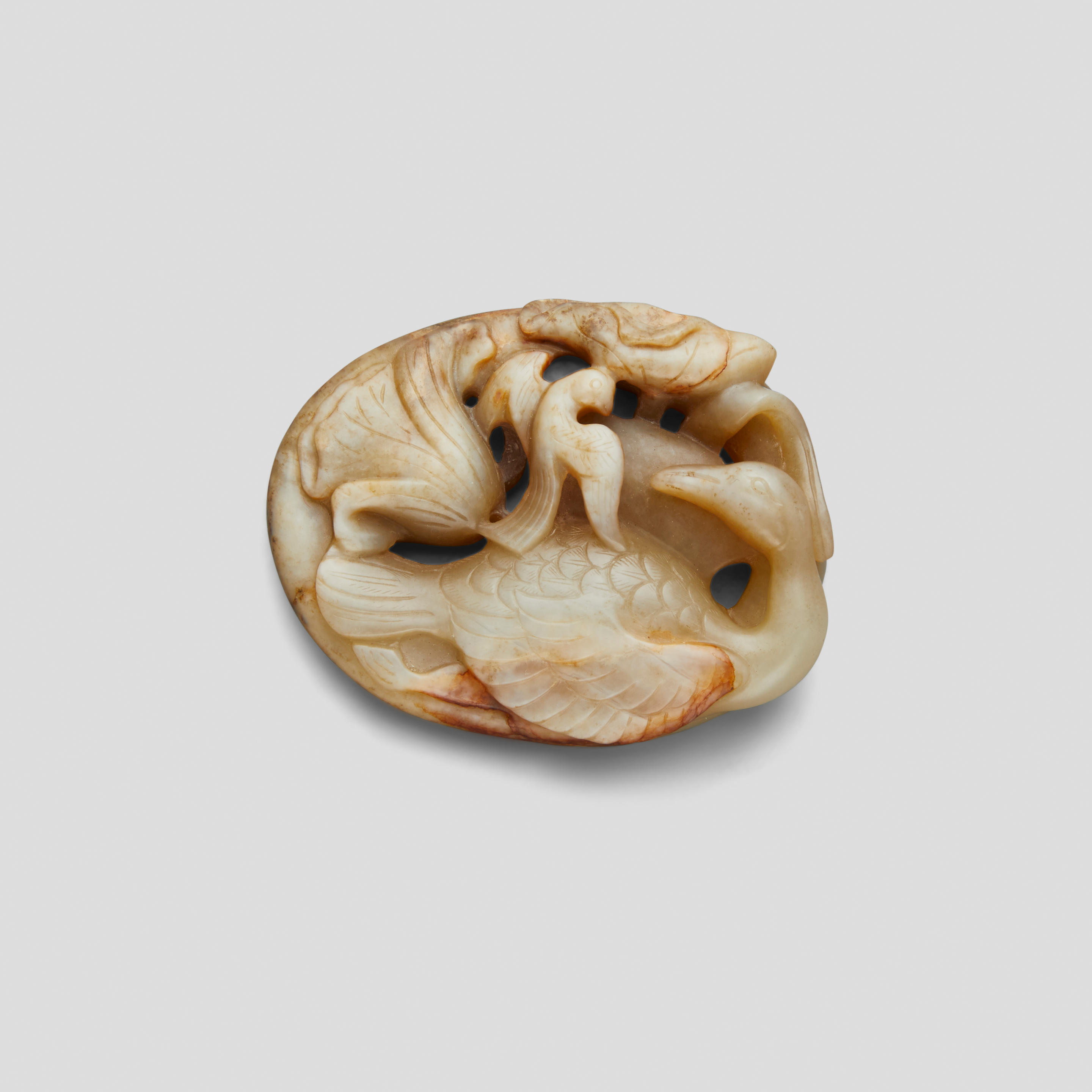 A MING STYLE CELADON AND BEIGE JADE BIRD AND LOTUS