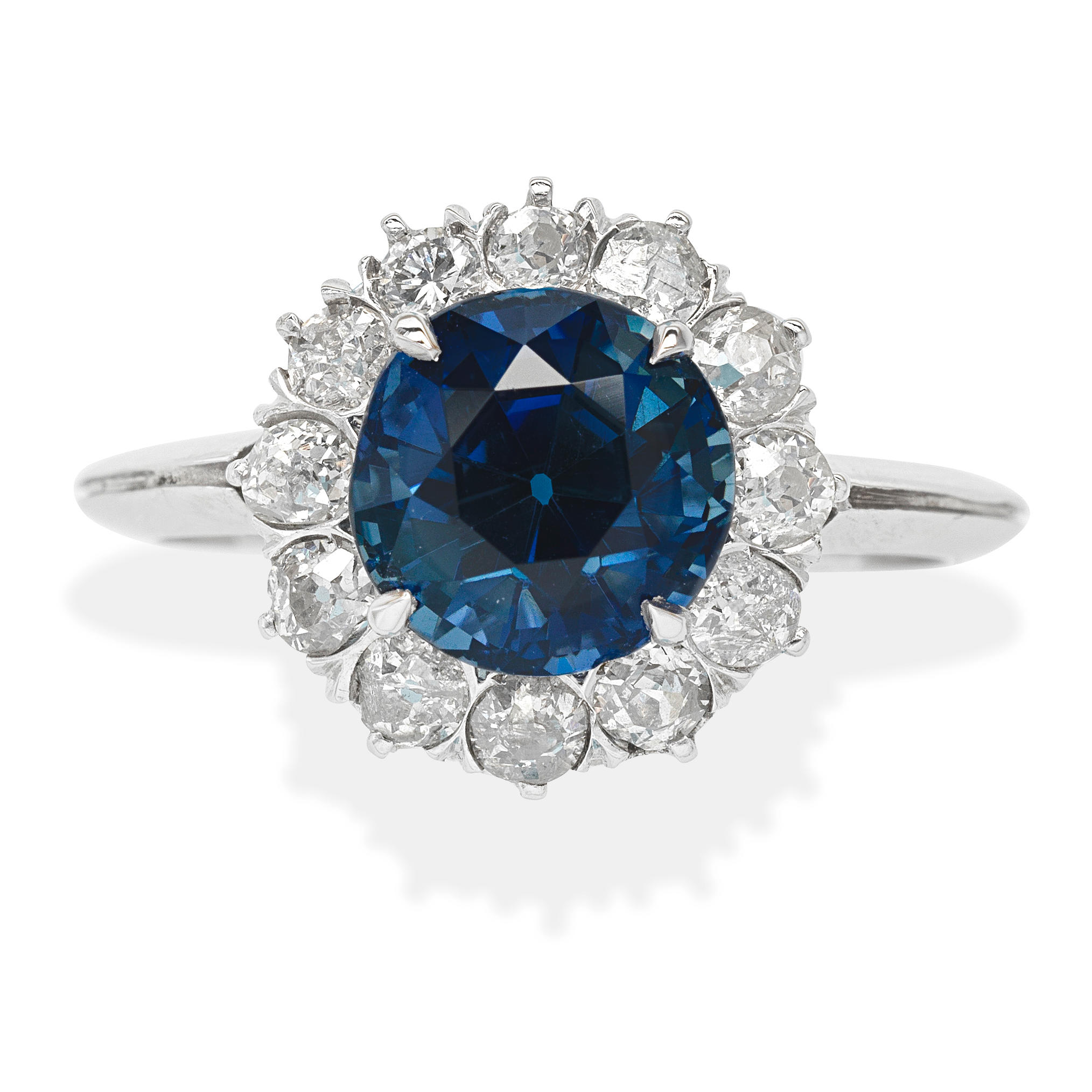 SAPPHIRE AND DIAMOND CLUSTER RING The circular cut sapphire within