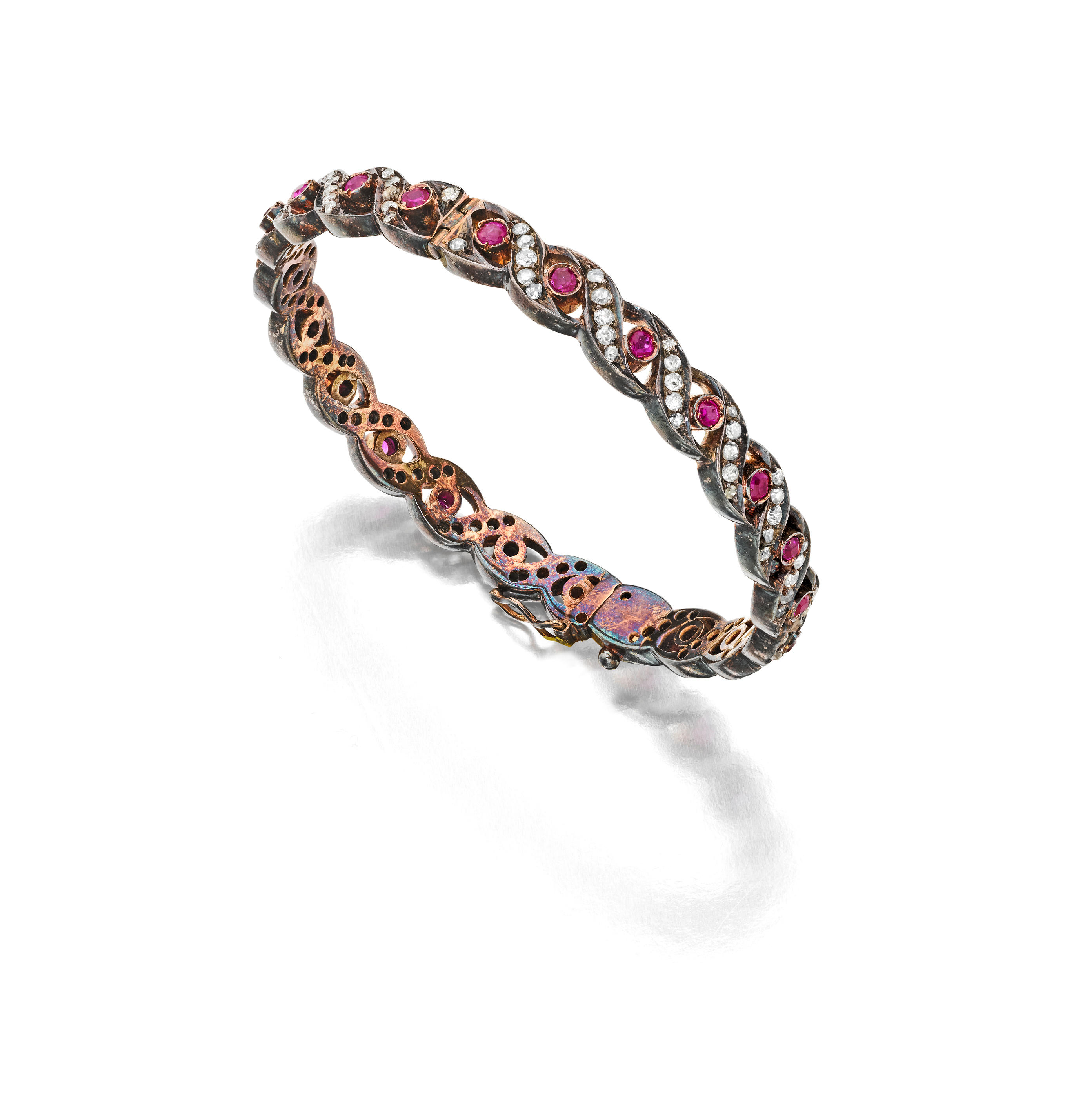 A RUBY AND DIAMOND BANGLE Of twisted design with round